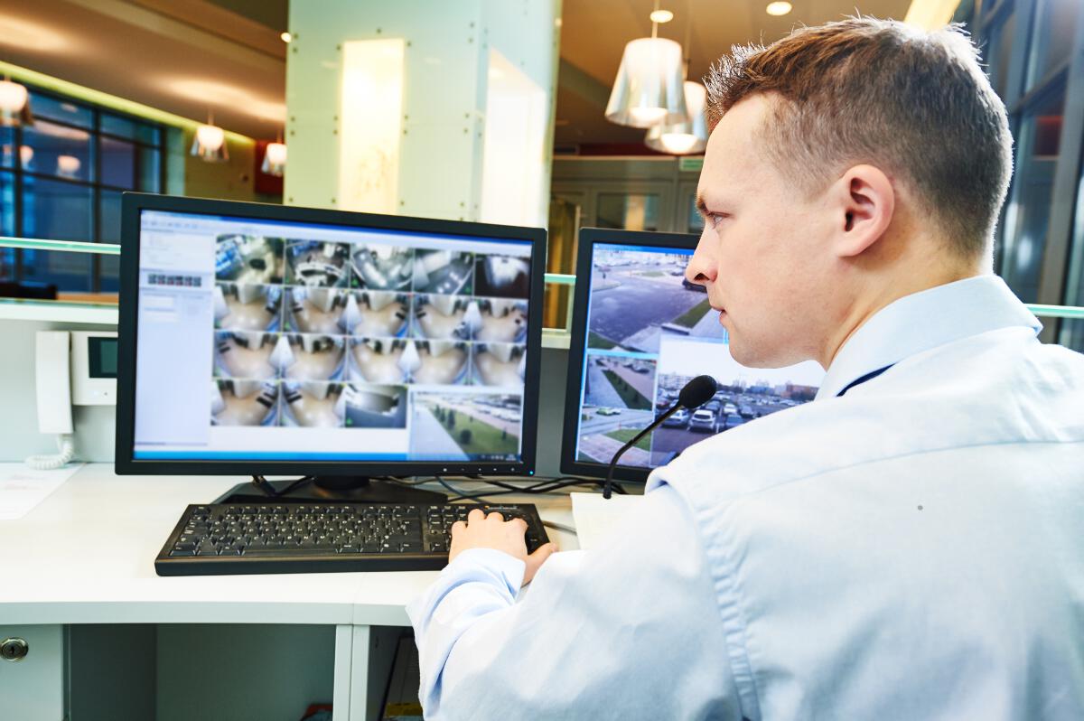 Security officer checking desktop surveillance videos