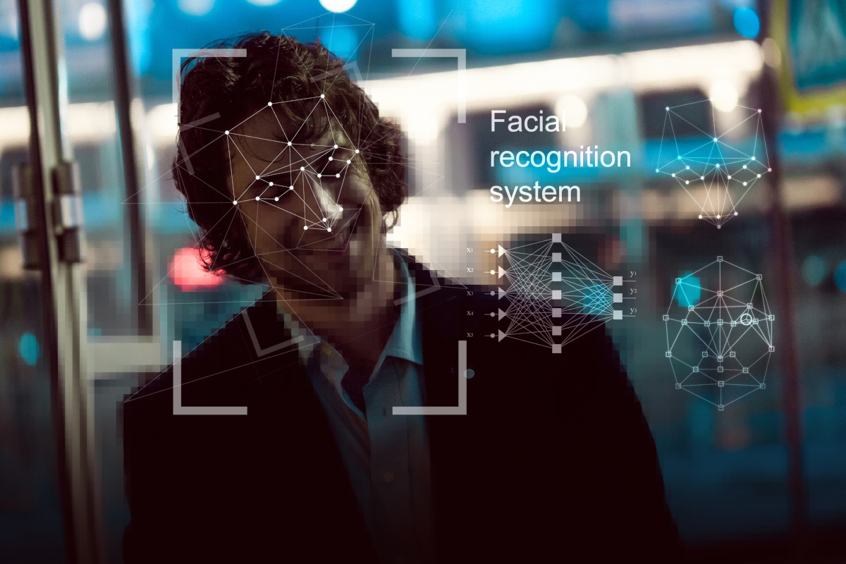 A Man in a suit having his face scanned by fical regonition softawre