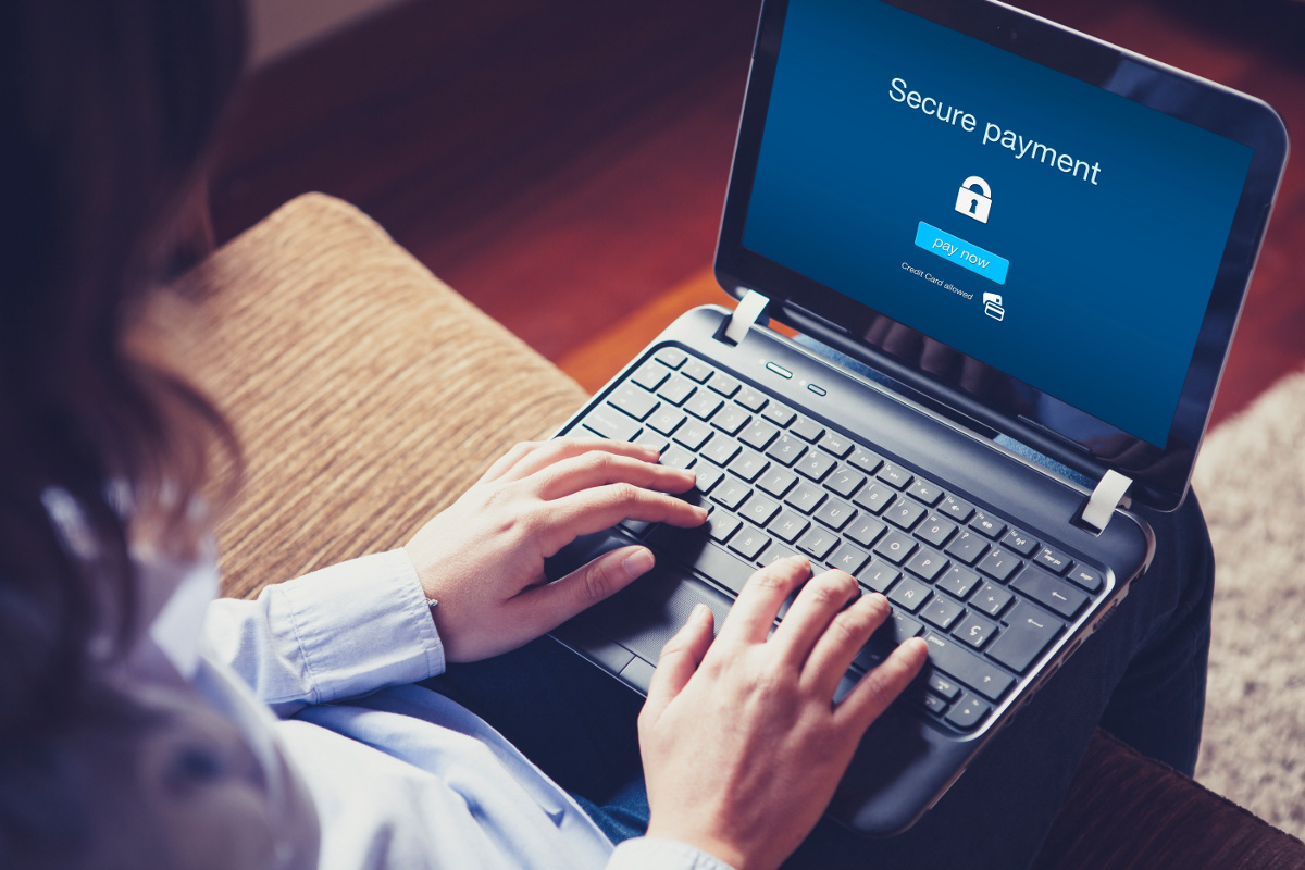 Woman Sitting in Front of Secure Payment Message on Laptop Screen