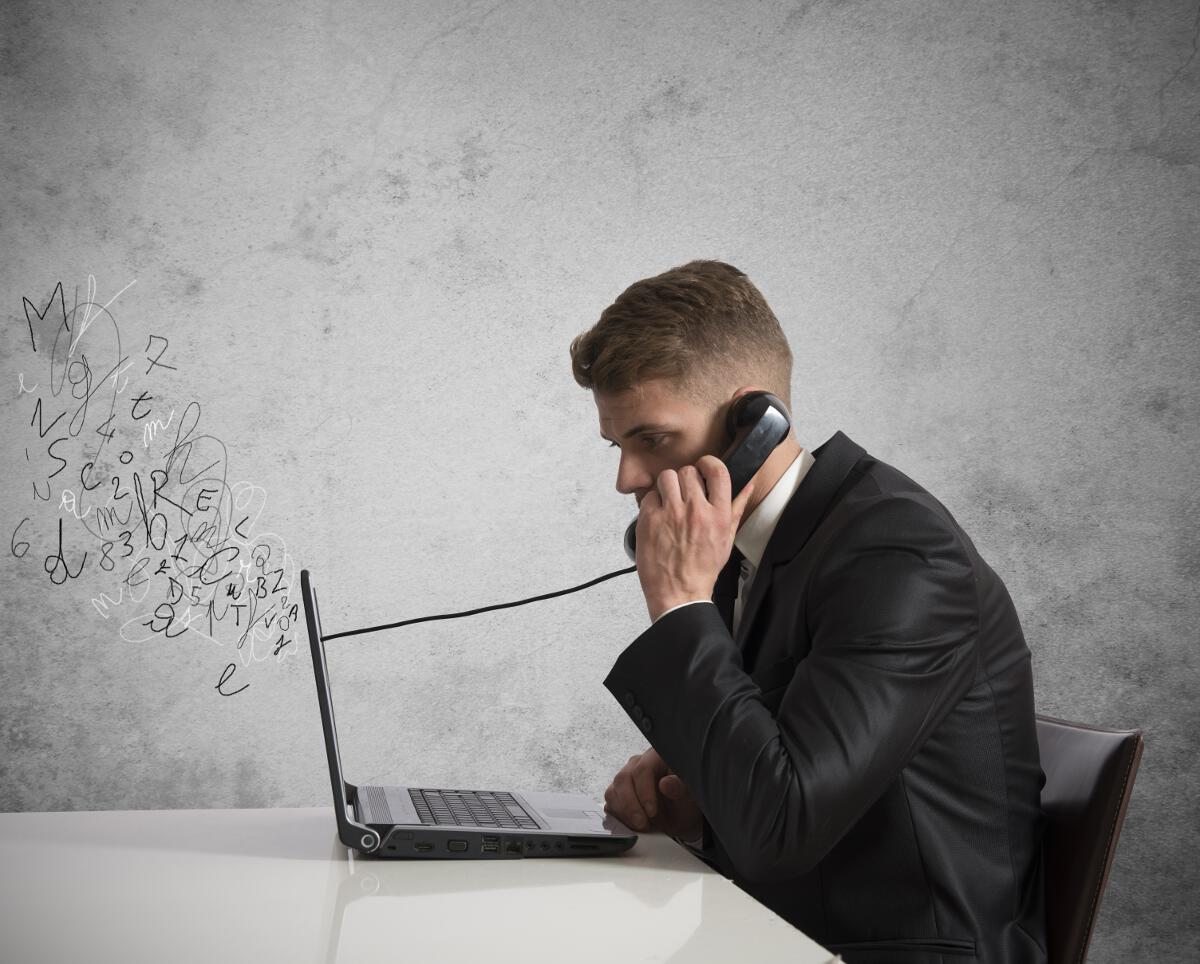 Man on laptop using a wired phone going through the screen