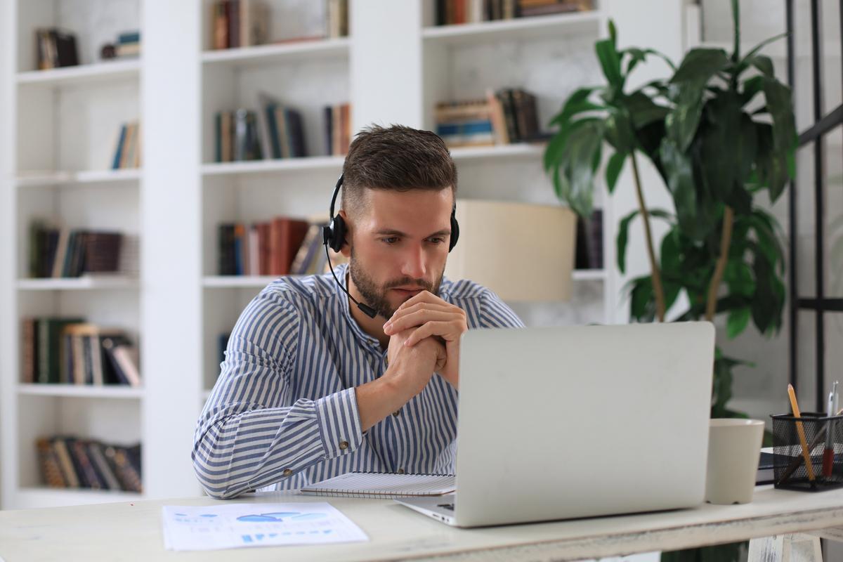 Man wearing headphones and using computer