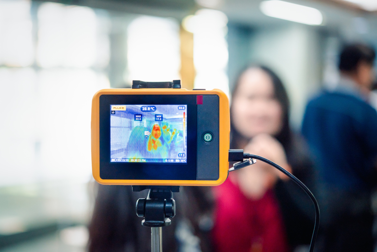 A women being scanned by a temperature scanner tablet