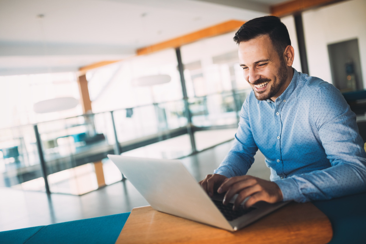 A smiling businessman working on his laptop