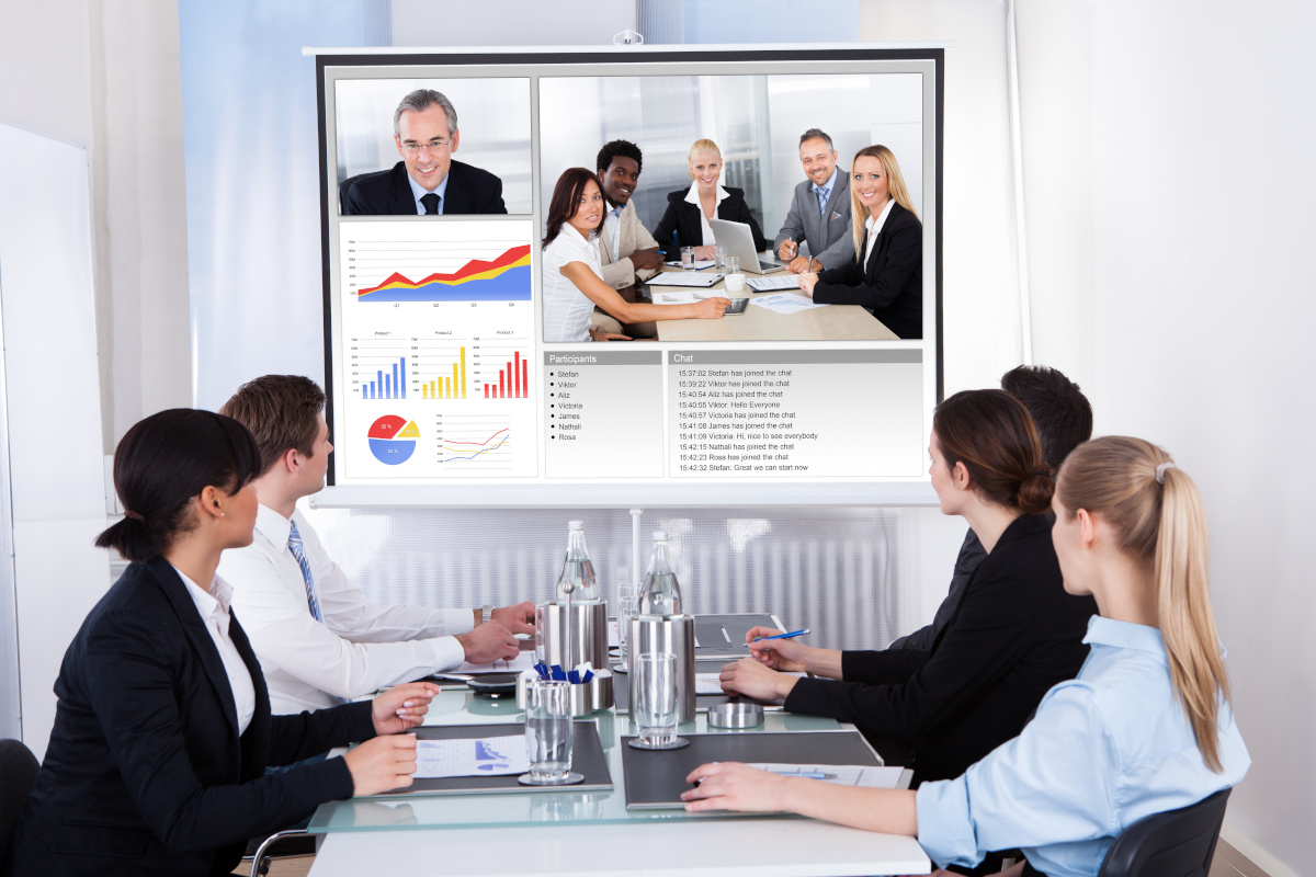 Business people holding a video conference with colleagues while in a video conferencing room