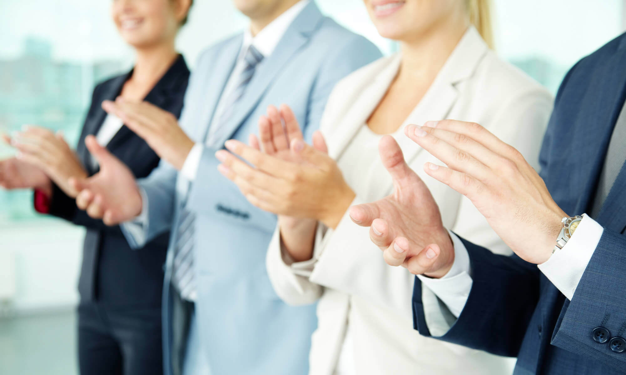 Close up of 4 business people's hands clapping